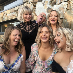 A group of women laughing in party outfits.