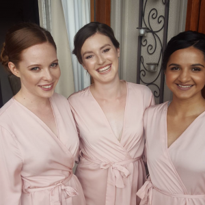 Bridesmaids in pink dressing gowns.